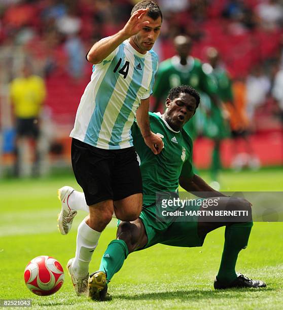 Argentinian midfielder Javier Mascherano is tackled by Nigerian defender Dele Adeleye during the men's Olympic football final Argentina vs. Nigeria...