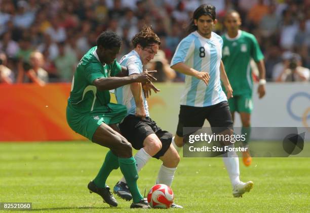 Dele Adeleye of Nigeria competes with Lionel Messi of Argentina in the Men's Gold Medal football match between Nigeria and Argentina at the National...