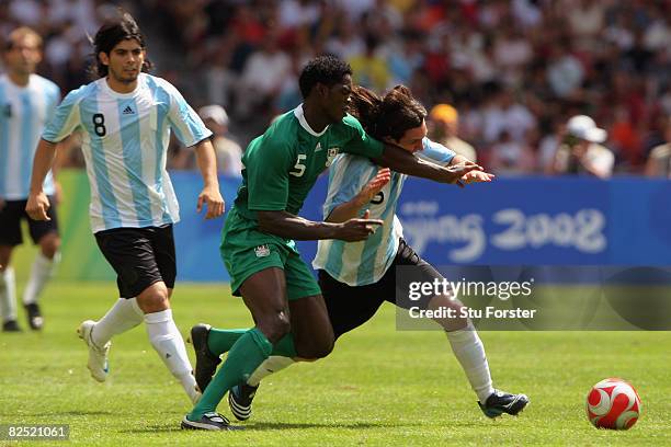 Dele Adeleye of Nigeria competes with Lionel Messi of Argentina in the Men's Gold Medal football match between Nigeria and Argentina at the National...