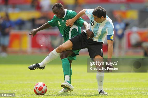 Juan Riquelme of Argentina competes with Sani Kaita of Nigeria in the Men's Gold Medal football match between Nigeria and Argentina at the National...