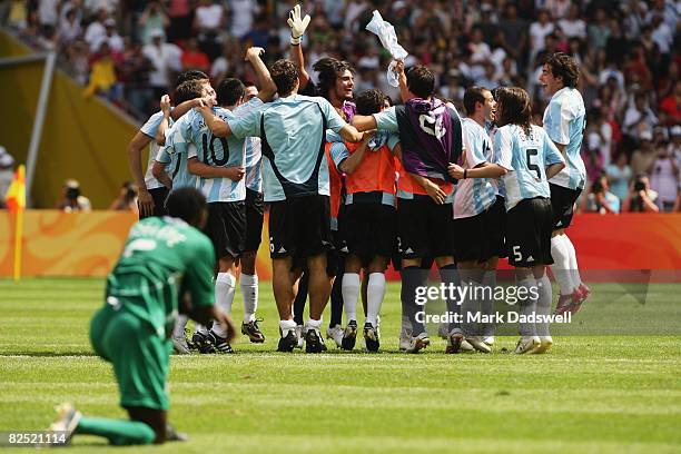 Argentina celebrate winning the Men's Gold Medal football match between Nigeria and Argentina as Dele Adeleye of Nigeria looks on at the National...