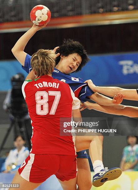 South Korea's Kim Ona is grabbed by Hungary's Zsuzsanna Tomori and Piroska Szamoransky during the women's handball bronze medal match of the 2008...