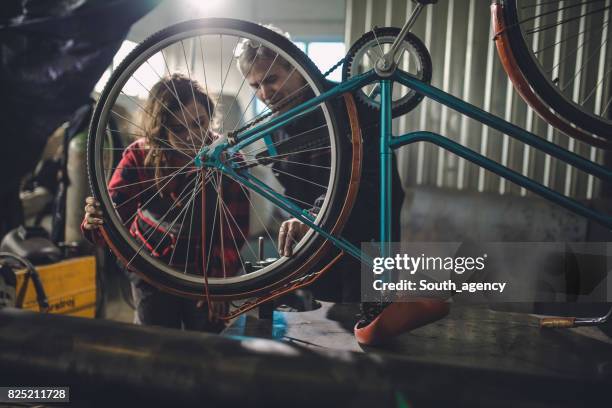 homme et femme, réparation vélo - roue vélo photos et images de collection