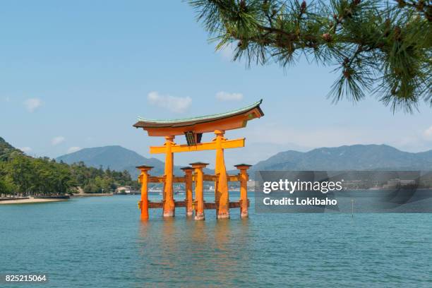 the famous torii gate on near miyajima island japan - torii gate stock pictures, royalty-free photos & images
