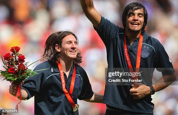 Lionel Messi and Sergio Romero of Argentina celebrate gold during the medal ceremony for the Men's Football at the National Stadium on Day 15 of the...