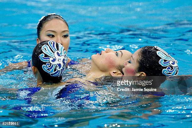 Hiromi Kobayashi of the Japan synchronized swim team is tended by teammates after an incident during competion in the synchronised swimming team...