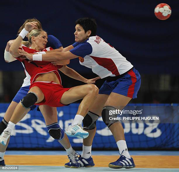 Norway's Gro Hammerseng is grabbed by Russia's Oxana Romenskaya during the women's handball gold medal match of the 2008 Beijing Olympic Games on...