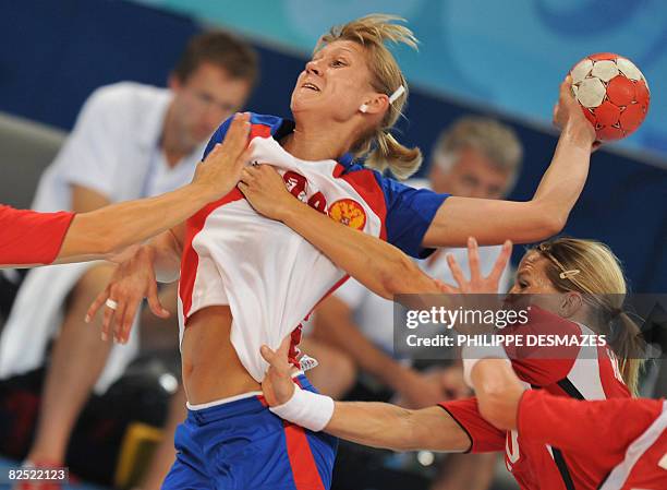 Russia's Irina Bliznova is grabbed by Norway's Gro Hammerseng during the women's handball gold medal match of the 2008 Beijing Olympic Games on...