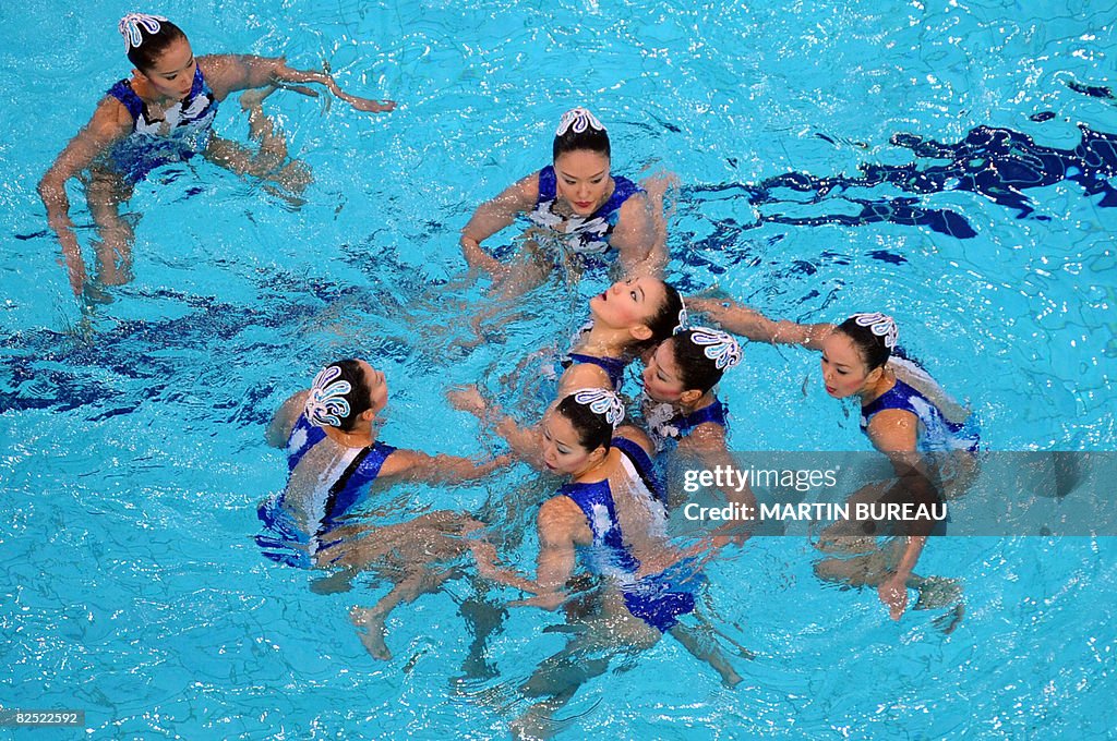 Japan's Kobayashi Hiromi (C) is helped b