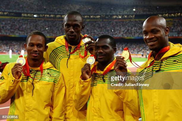 Michael Frater, Usain Bolt, Nesta Carter and Asafa Powell of Jamaica receive their gold medals during the medal ceremony for the Men's 4 x 100m Relay...