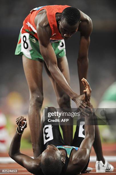 Sudan's Ismail Ahmed Ismail holds the hand of Kenya's Wilfred Bungei as he lies on the ground after crossing the finishline in the men's 800m final...