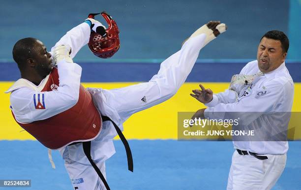 Angel Valodia Matos of Cuba lands a kick on the face of referee Chakir Chelbat of Sweden after he lost his bronze medal contest in the men's +80 kg...