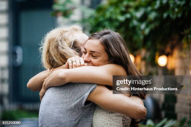 young couple embrace each other lovingly at barbecue meetup - abbracciare una persona foto e immagini stock