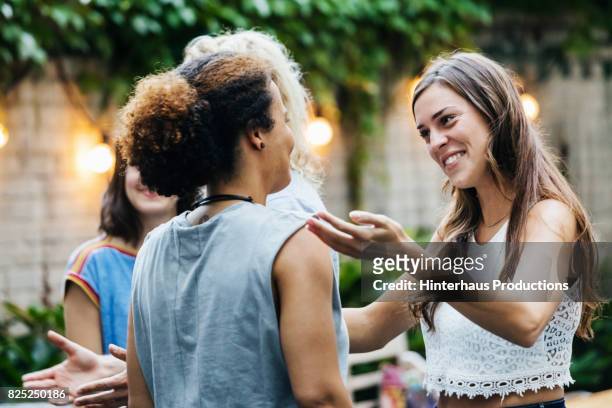two young women greeting each other during barbecue meetup - welcoming 個照片及圖片檔