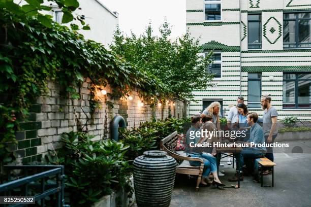 a group of friends gathered around table preparing for barbecue - townhouse foto e immagini stock