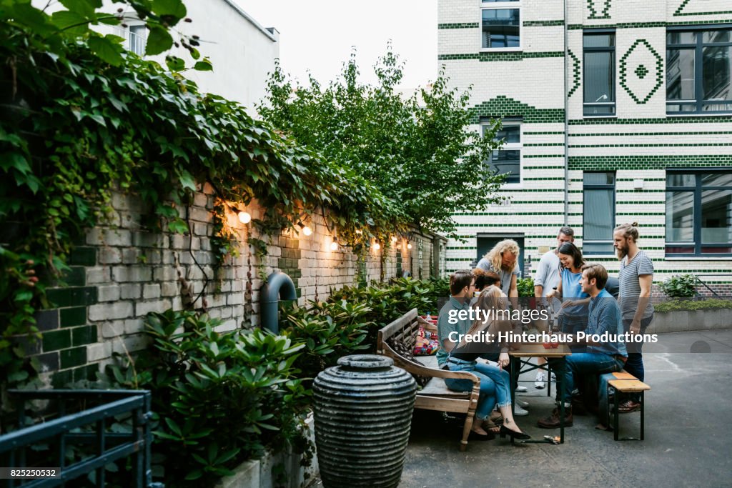 A Group Of Friends Gathered Around Table Preparing For Barbecue