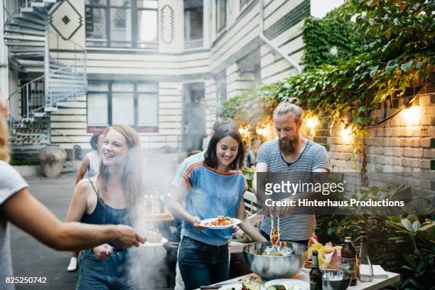 group of friends having a barbecue, getting ready to eat. - garden summer enjoy stock-fotos und bilder