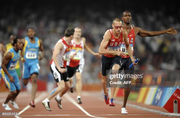 Jeremy Wariner of the US runs with the baton towards the finishline to win the men's 4x400m relay final at the "Bird's Nest" National Stadium during...