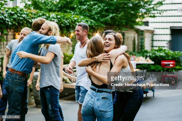 young group of friends meeting up for barbecue, hugging and greeting each other. - party stock-fotos und bilder