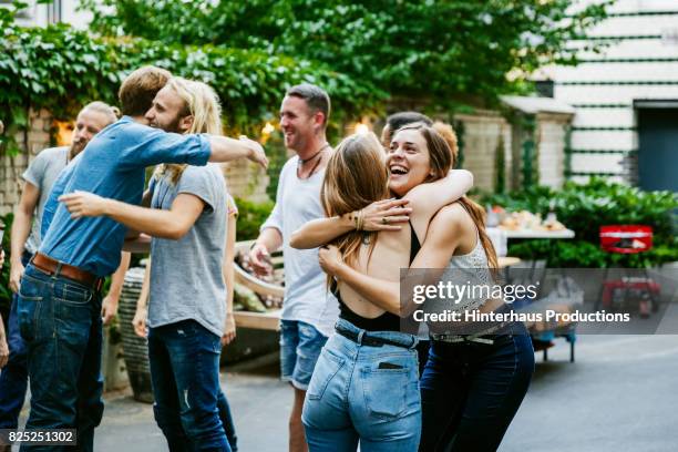 young group of friends meeting up for barbecue, hugging and greeting each other. - copain photos et images de collection