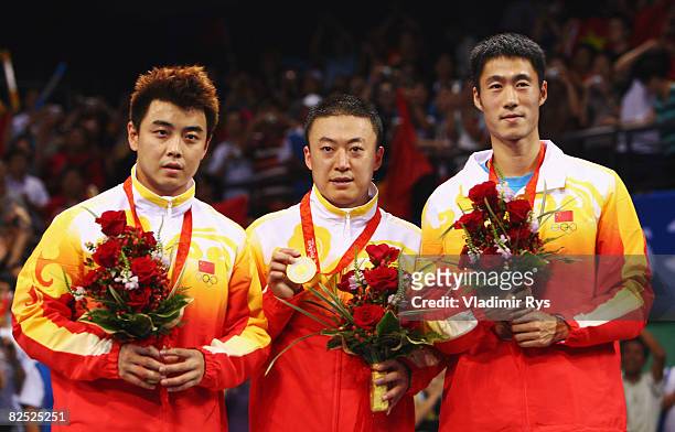 Silver medallist Wang Hao of China, gold medallist Ma Lin of China and bronze medallist Wang Liqin of China celebrate with their medals after the...