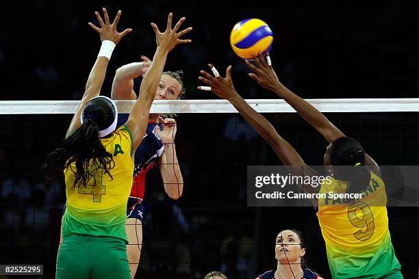 Heather Bown of the United States spikes a shot past Paula Pequeno and Fabiana Claudino of Brazil during the women's gold medal volleyball game held...