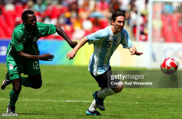Lionel Messi of Argentina and Ebenezer Ajilore of Nigeria compete for the ball during the Men's Final between Nigeria and Argentina at the National...