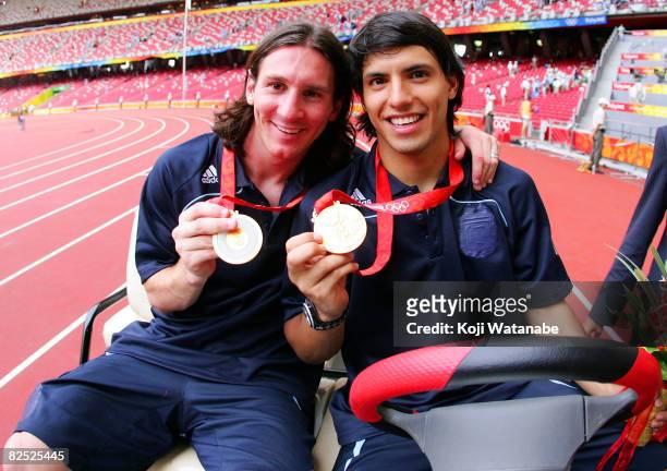 Argentinian forwards Lionel Messi and Sergio Aguero gold medal pose during the men's Olympic football tournament medal ceremony at the national...