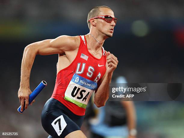 Jeremy Wariner of the US celebrate runs with the baton during the men's 4x400m relay final at the "Bird's Nest" National Stadium during the 2008...