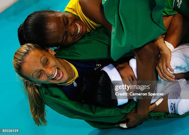 Fabiana Claudino , Fabiana de Oliveira and Paula Pequeno of Brazil celebrate after winning the women's gold medal volleyball game against the United...