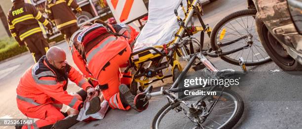 sanitäter helfen verletzten radfahrer - unfall stock-fotos und bilder