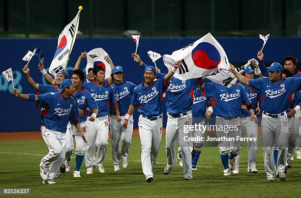 Players from Korea take a lap around the outfield as they celebrate their 3-2 win against Cuba during the men's gold medal baseball game held at...
