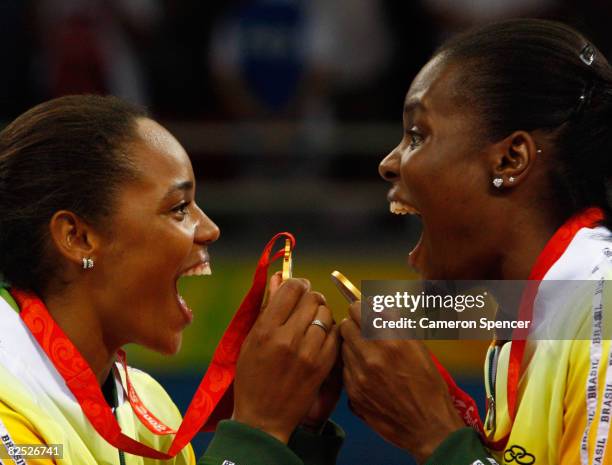 Welissa Gonzaga and Fabiana Claudino of Brazil celebrate on the podium with their gold medals after they defeated the United States during the...
