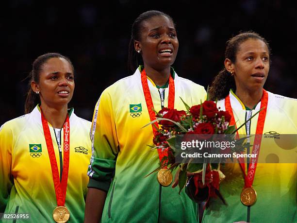 Welissa Gonzaga, Fabiana Claudino of Brazil and Valeska Menezes sing the national anthem on the podium with their gold medals after they defeated the...