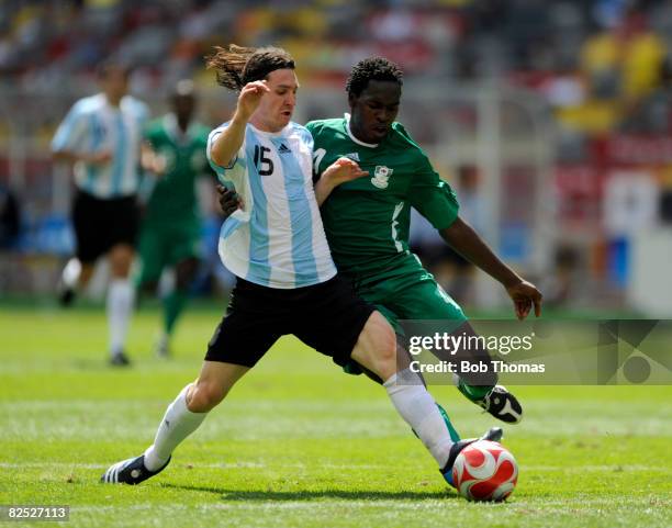 Lionel Messi of Argentina competes for the ball with Onyekachi Apam of Nigeria during the Men's Gold Medal football match between Nigeria and...