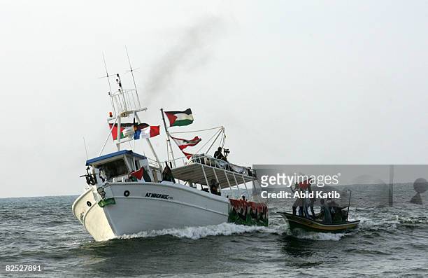 Palestinians ride a fishing boat as they greet the U.S.-based Free Gaza protest group on one of two boats upon its arrival from Cyprus August 23,...