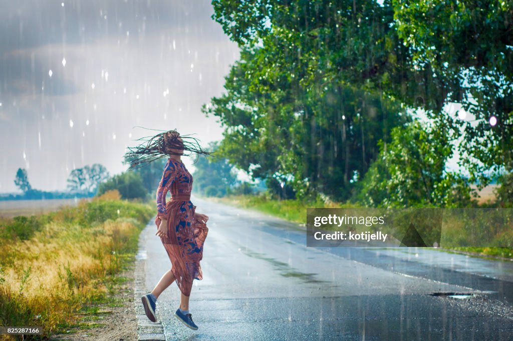 Frau tanzt im Regen