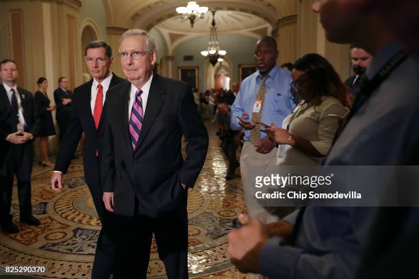 Senate Majority Leader Mitch McConnell and Sen. John Barrasso talk with reporters following the Republican Senate policy luncheon at the U.S. Capitol...