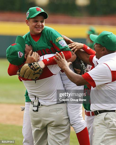 Manager Gustavo Gomez lifts up Jesus Sauceda of Mexico to celebrate after defeating Japan in the International Final at Lamade Stadium on August 23,...