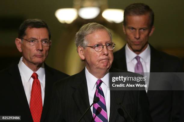 Senate Majority Leader Sen. Mitch McConnell speaks to members of the media at the Capitol as Sen. John Barrasso and Sen. John Thune listen August 1,...