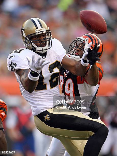 Marques Colston of the New Orleans Saints and Leon Hall of the Cincinnati Bengals abattle for the ball during the NFL game at Paul Brown Stadium on...