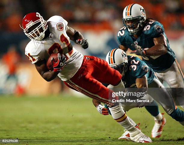 Running back Kolby Smith of the Kansas City Chiefs runs during a pre season game against defenders Jason Allen and Channing Crowder of the Miami...