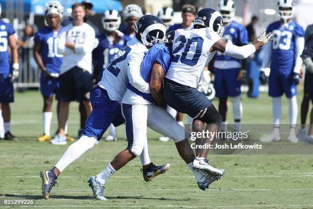 Tavon Austin of the Los Angeles Rams is able to hold the reception after being sandwiched by Lamarcus Joyner and Troy Hill during Training Camp at...