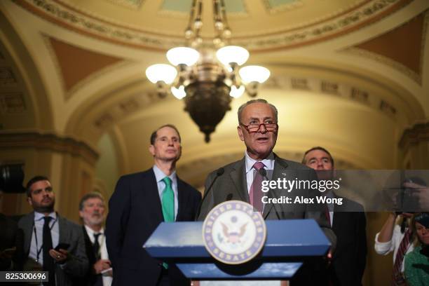 Senate Minority Leader Sen. Chuck Schumer speaks as Sen. Ron Wyden and Sen. Michael Bennet listen during a media briefing at the Capitol August 1,...