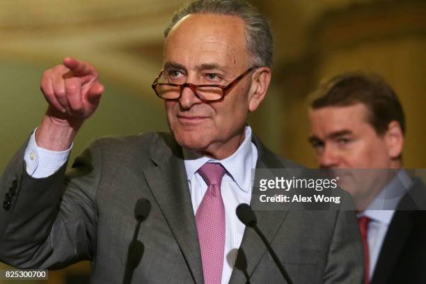 Senate Minority Leader Sen. Chuck Schumer takes questions as Sen. Michael Bennet looks on during a media briefing at the Capitol August 1, 2017 in...