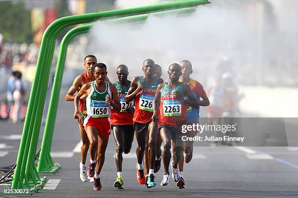 Merga Deriba of Ethiopia , Martin Lel of Kenya and Sammy Wanjiru of Kenya run under water sprinklers during the Men's Marathon on the way to the...