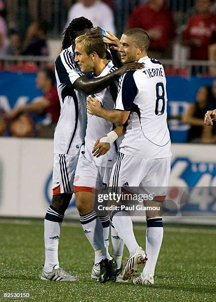 Shalrie Joseph celebrates the first goal of the match with Taylor Twellman and Chris Tierney of the New England Revolution during their match against...