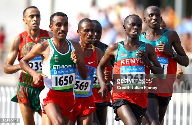 Merga Deriba of Ethiopia and Sammy Wanjiru of Kenya lead a pack of runners during the Men's Marathon on the way to the National Stadium during Day 16...