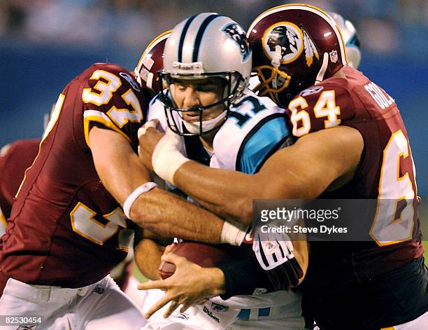 Jake Delhomme of the Carolina Panthers is sacked by Reed Doughty and Kedric Golston of the Washington Redskins in the first quarter of the NFL...