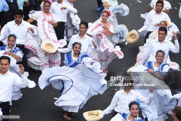 People take part in a parade marking the start of San Salvador's patron saint's festival in honor of Divino Salvador del Mundo , in San Salvador, on...